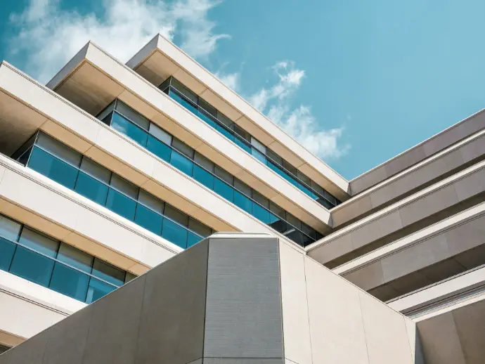 low angle photo of beige concrete building under cloudy sky